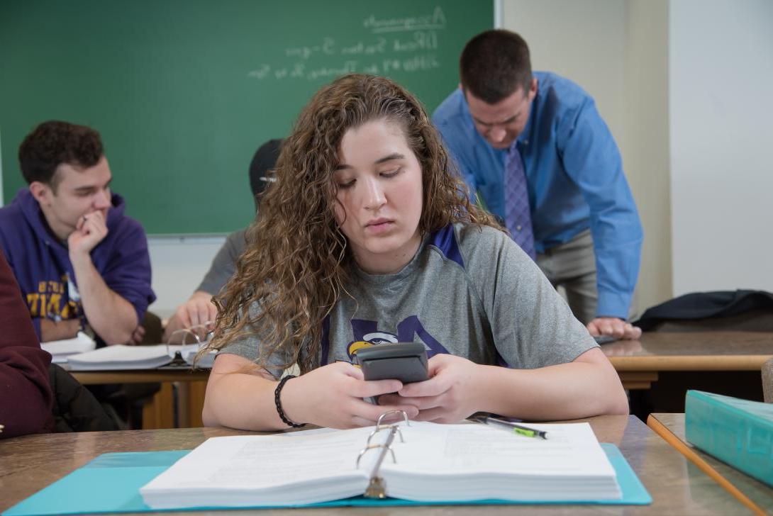 Student in math class using a calculator